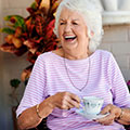 mature woman laughing drinking tea