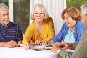 four mature adults playing a board game