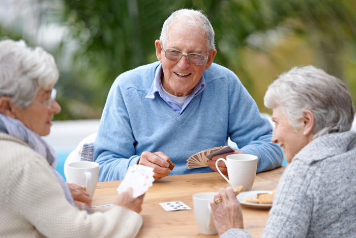 three mature adults socializing outdoors